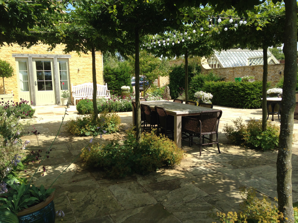 Expansive traditional garden in Gloucestershire with river rock.