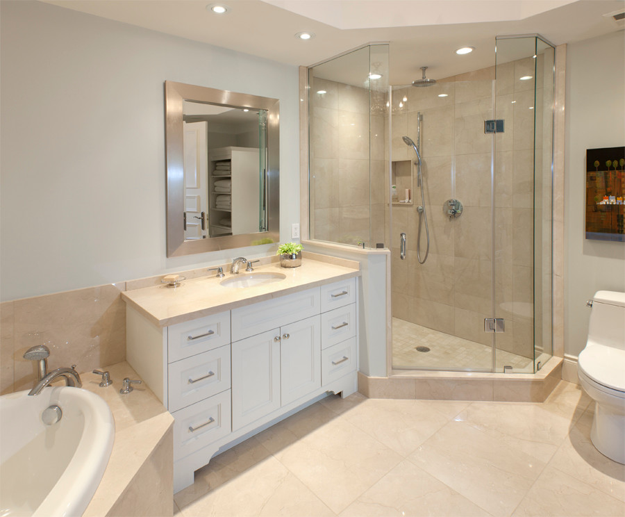 Design ideas for a mid-sized traditional master bathroom in Toronto with recessed-panel cabinets, white cabinets, a corner tub, an alcove shower, a one-piece toilet, beige tile, stone tile, beige walls, marble floors, an undermount sink, marble benchtops, beige floor and a hinged shower door.