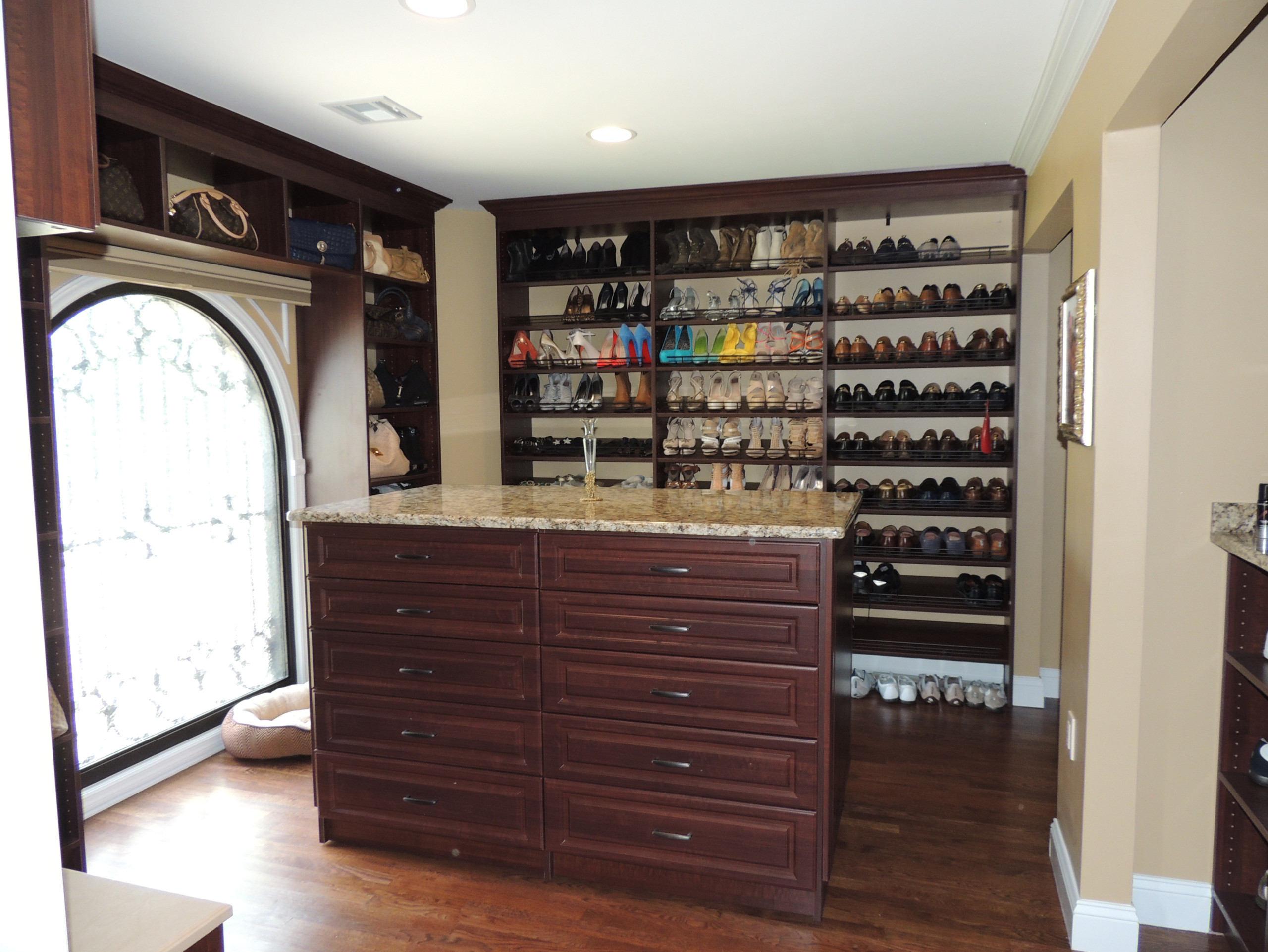 Closet has a large window and the clients wanted to have shelving to go around the window.  There is a large island with twenty drawers.  All the drawers have custom jewelry, tie and dividers.  There