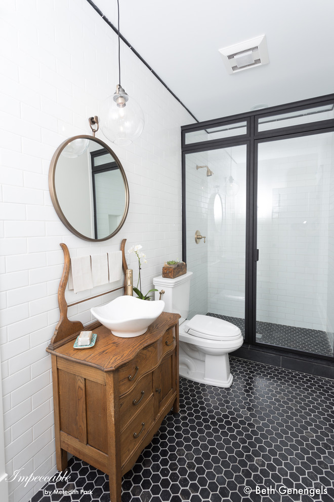 Design ideas for a mid-sized transitional 3/4 bathroom in Chicago with furniture-like cabinets, medium wood cabinets, an alcove shower, a two-piece toilet, white tile, porcelain tile, white walls, porcelain floors, a vessel sink, wood benchtops, black floor and a hinged shower door.