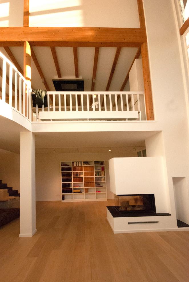 Geräumiges, Repräsentatives Modernes Wohnzimmer im Loft-Stil mit hellem Holzboden, unterschiedlichen Kaminen und Kaminumrandungen in Düsseldorf