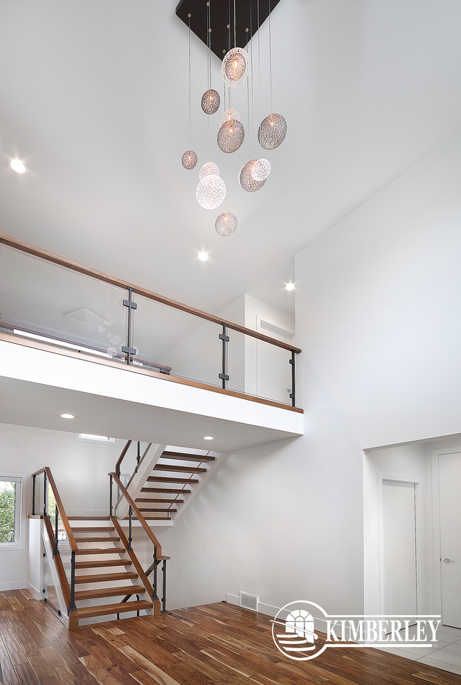This is an example of a modern foyer in Edmonton with white walls and medium hardwood floors.