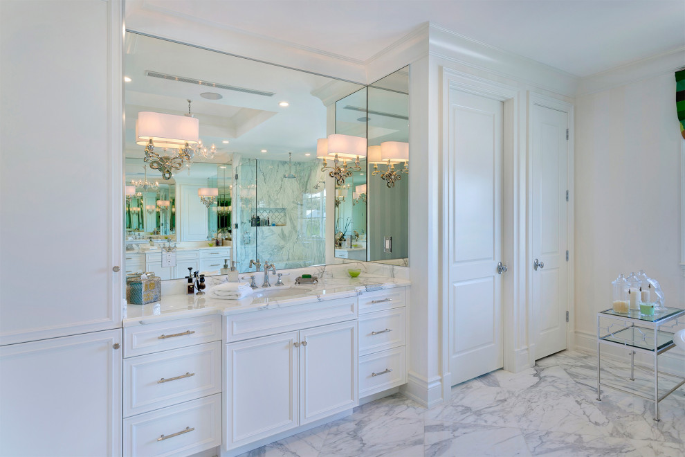 Example of a mid-sized transitional master beige tile and porcelain tile porcelain tile and beige floor alcove shower design in Miami with shaker cabinets, white cabinets, a one-piece toilet, multicolored walls, an undermount sink, marble countertops, a hinged shower door and white countertops