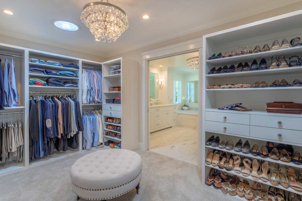 Photo of a large transitional dressing room in Los Angeles with recessed-panel cabinets, white cabinets, carpet and beige floor.