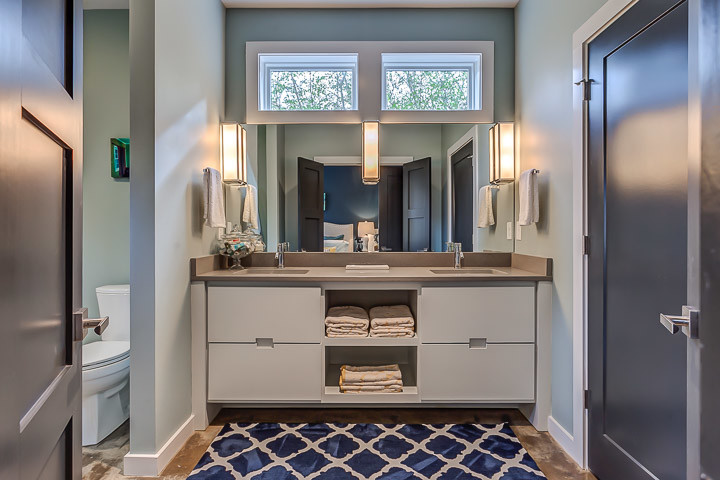 Design ideas for a modern 3/4 bathroom in Nashville with an undermount sink, furniture-like cabinets, white cabinets, engineered quartz benchtops, an open shower, a two-piece toilet, blue walls and concrete floors.