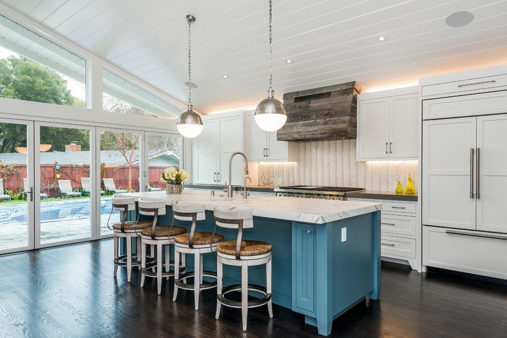 Mid-sized transitional single-wall dark wood floor and brown floor eat-in kitchen photo in San Francisco with a farmhouse sink, shaker cabinets, white cabinets, marble countertops, white backsplash, stainless steel appliances, an island and matchstick tile backsplash