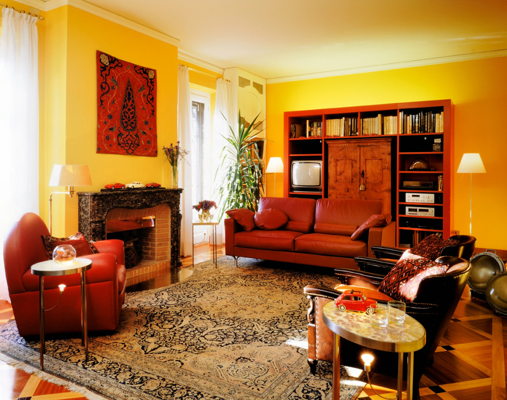Exemple d'un grand salon éclectique fermé avec une salle de réception, un mur jaune, parquet foncé, une cheminée standard, un manteau de cheminée en pierre, un téléviseur encastré et un sol marron.
