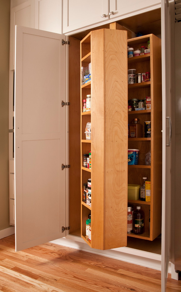 Mid-sized traditional l-shaped kitchen pantry in Seattle with an undermount sink, white cabinets, marble benchtops, brown splashback, stainless steel appliances, medium hardwood floors, with island, glass-front cabinets and matchstick tile splashback.