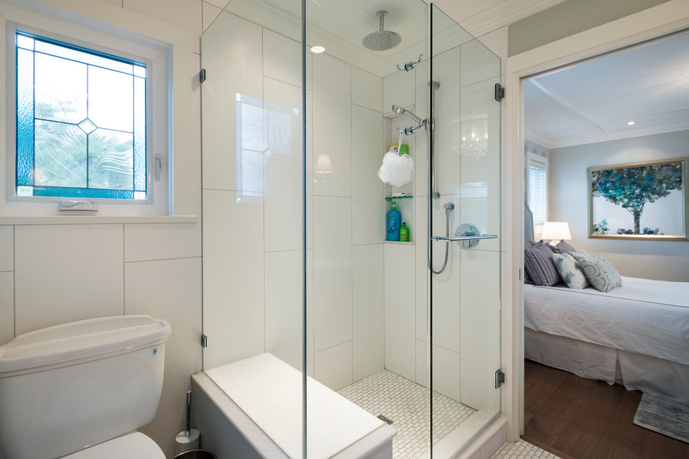 This is an example of a mid-sized transitional master bathroom in Vancouver with shaker cabinets, blue cabinets, a corner shower, a two-piece toilet, multi-coloured tile, glass sheet wall, grey walls, mosaic tile floors, an undermount sink and quartzite benchtops.
