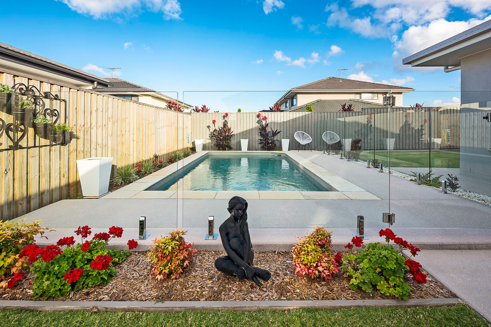 This is an example of a large contemporary backyard rectangular lap pool in Brisbane with natural stone pavers.