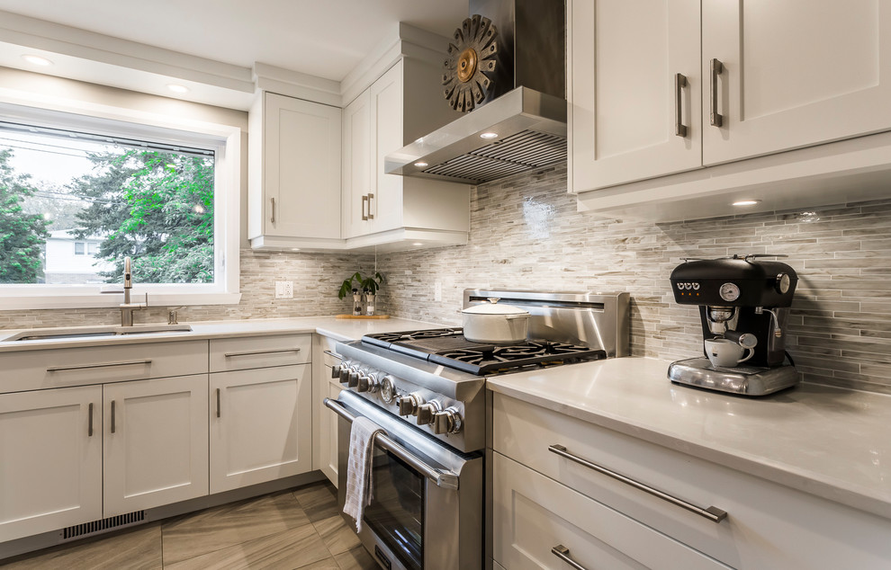 Inspiration for a mid-sized transitional l-shaped porcelain tile and gray floor eat-in kitchen remodel with an undermount sink, shaker cabinets, white cabinets, quartz countertops, multicolored backsplash, matchstick tile backsplash, stainless steel appliances and an island