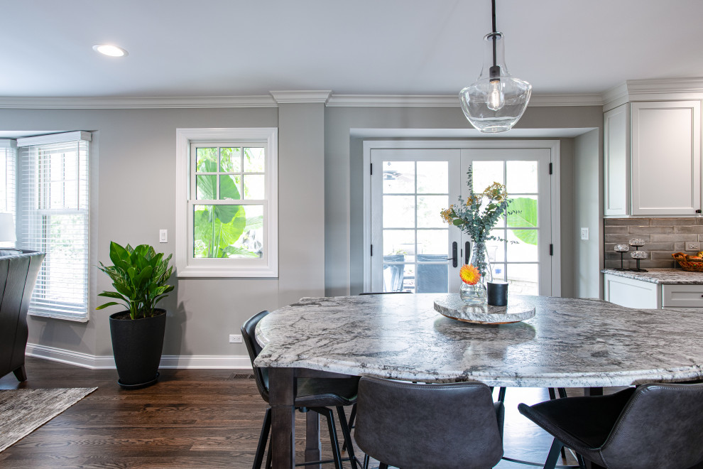 Open concept kitchen - mid-sized transitional u-shaped dark wood floor and brown floor open concept kitchen idea in Chicago with a double-bowl sink, shaker cabinets, white cabinets, quartz countertops, blue backsplash, porcelain backsplash, stainless steel appliances, an island and gray countertops