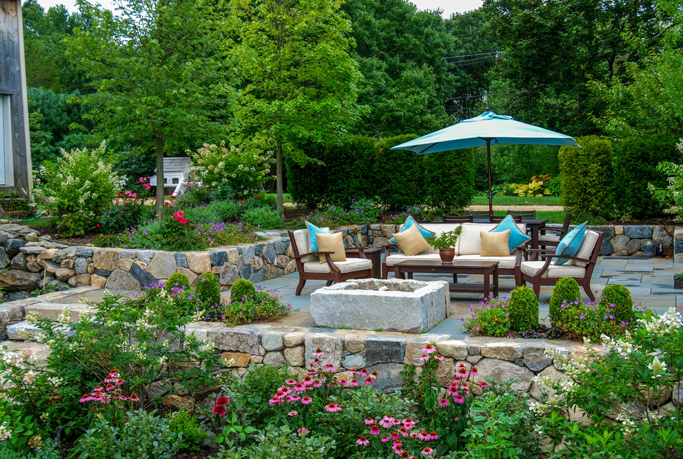 Inspiration for a mid-sized country backyard patio in Boston with a fire feature and natural stone pavers.