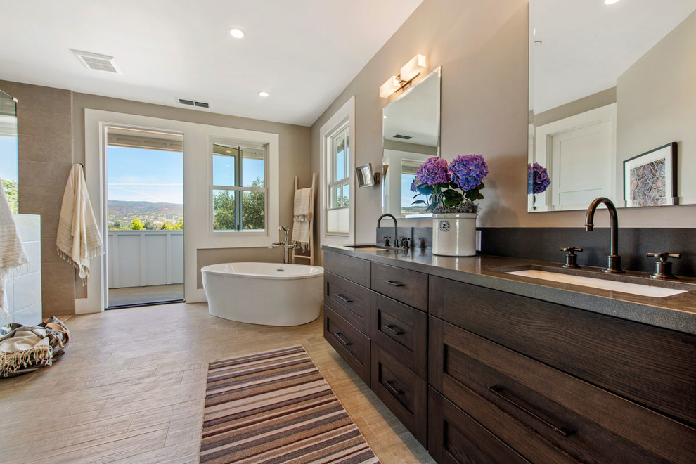 This is an example of a large country master bathroom in San Francisco with recessed-panel cabinets, black cabinets, a freestanding tub, a curbless shower, blue tile, porcelain tile, grey walls, porcelain floors, an undermount sink and limestone benchtops.