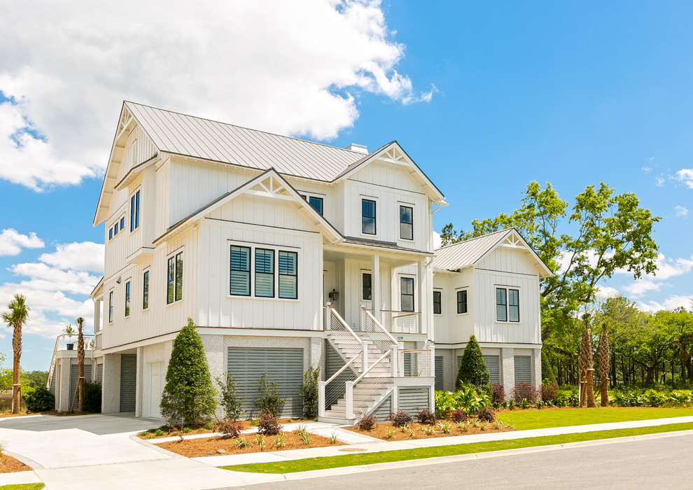 Example of a large beach style white two-story concrete fiberboard exterior home design in Charleston with a metal roof