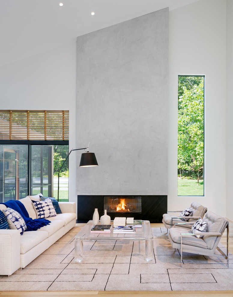 Living room - scandinavian open concept medium tone wood floor living room idea in New York with white walls, a standard fireplace, a metal fireplace and no tv