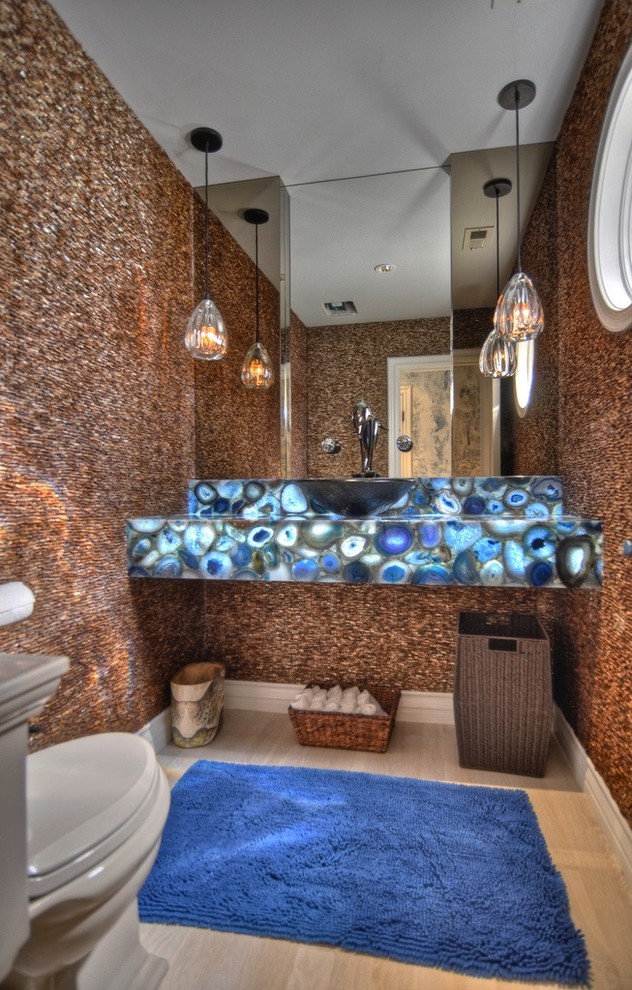 This is an example of a mid-sized beach style powder room in Las Vegas with a two-piece toilet, red tile, mosaic tile, red walls, light hardwood floors, a vessel sink, onyx benchtops, beige floor and blue benchtops.