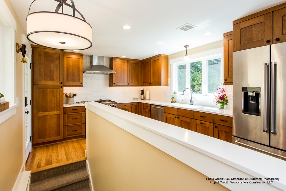 Example of a mid-sized mountain style l-shaped medium tone wood floor and brown floor eat-in kitchen design in Seattle with an undermount sink, shaker cabinets, medium tone wood cabinets, quartzite countertops, white backsplash, porcelain backsplash, stainless steel appliances and no island