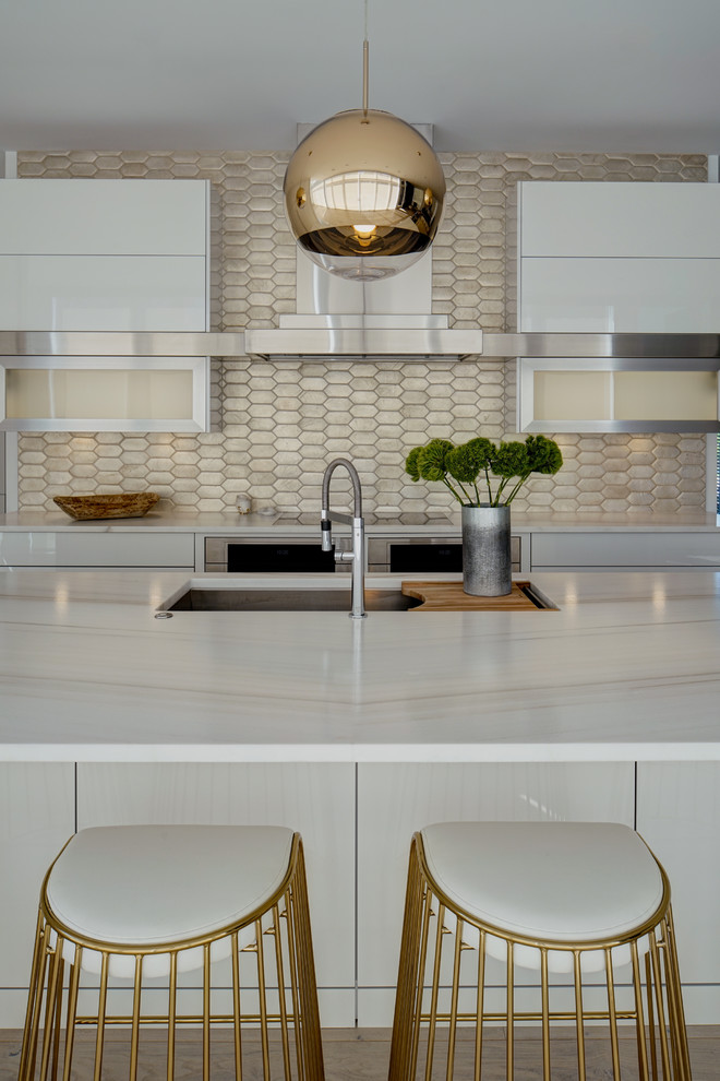 Photo of a large contemporary l-shaped eat-in kitchen in Chicago with an undermount sink, flat-panel cabinets, white cabinets, marble benchtops, metallic splashback, terra-cotta splashback, stainless steel appliances, light hardwood floors and with island.