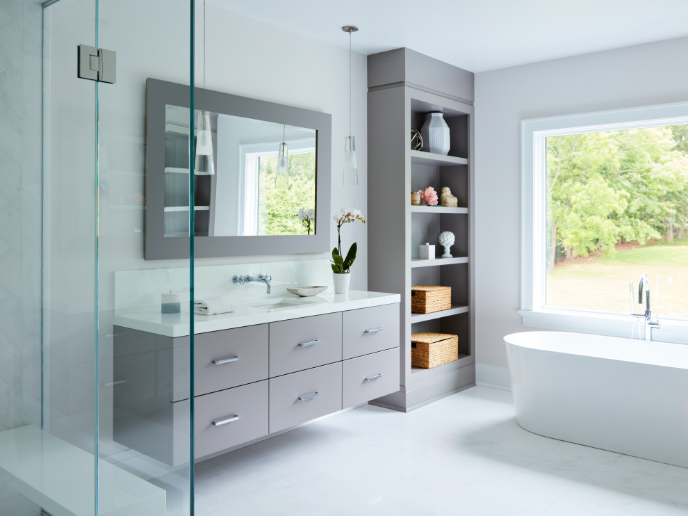 Photo of a mid-sized transitional master bathroom in New York with flat-panel cabinets, grey cabinets, a freestanding tub, a corner shower, grey walls, porcelain floors, an undermount sink, engineered quartz benchtops, white floor, a hinged shower door, white benchtops, a single vanity and a floating vanity.