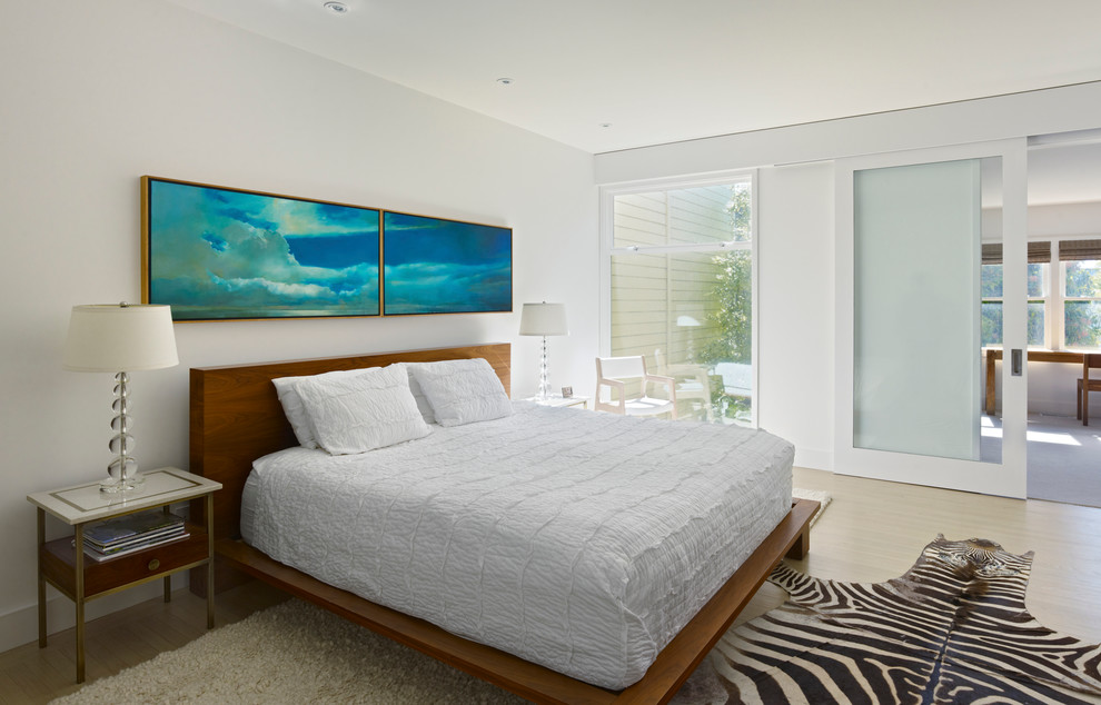 Photo of a large modern master bedroom in San Francisco with white walls, light hardwood floors and no fireplace.