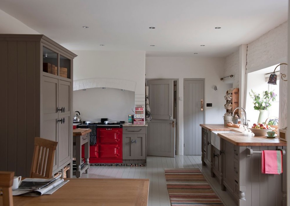 Mid-sized country u-shaped eat-in kitchen in London with a farmhouse sink, grey cabinets, wood benchtops, painted wood floors, no island, shaker cabinets and coloured appliances.