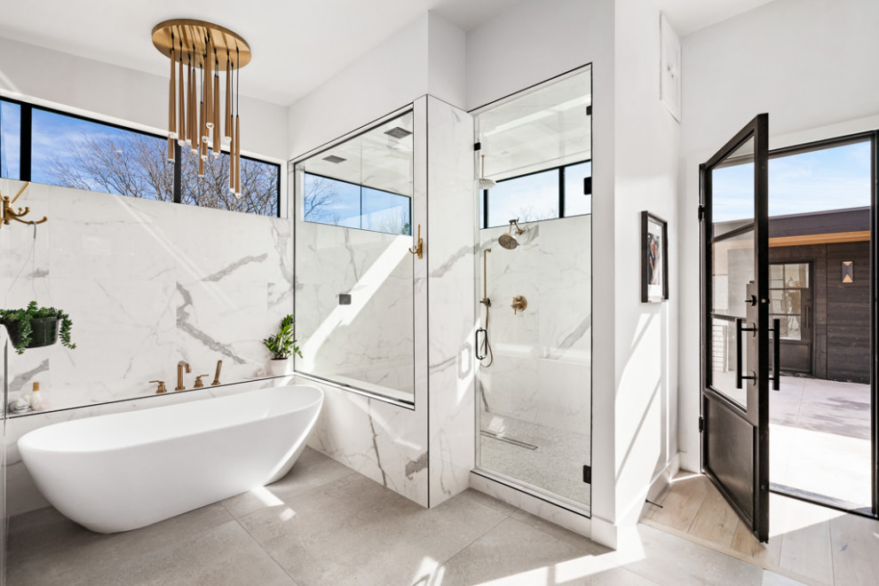 Photo of a modern master bathroom in Denver with flat-panel cabinets, medium wood cabinets, a freestanding tub, a double shower, white tile, marble, white walls, porcelain floors, a vessel sink, quartzite benchtops, grey floor, a hinged shower door, white benchtops, a double vanity and a floating vanity.