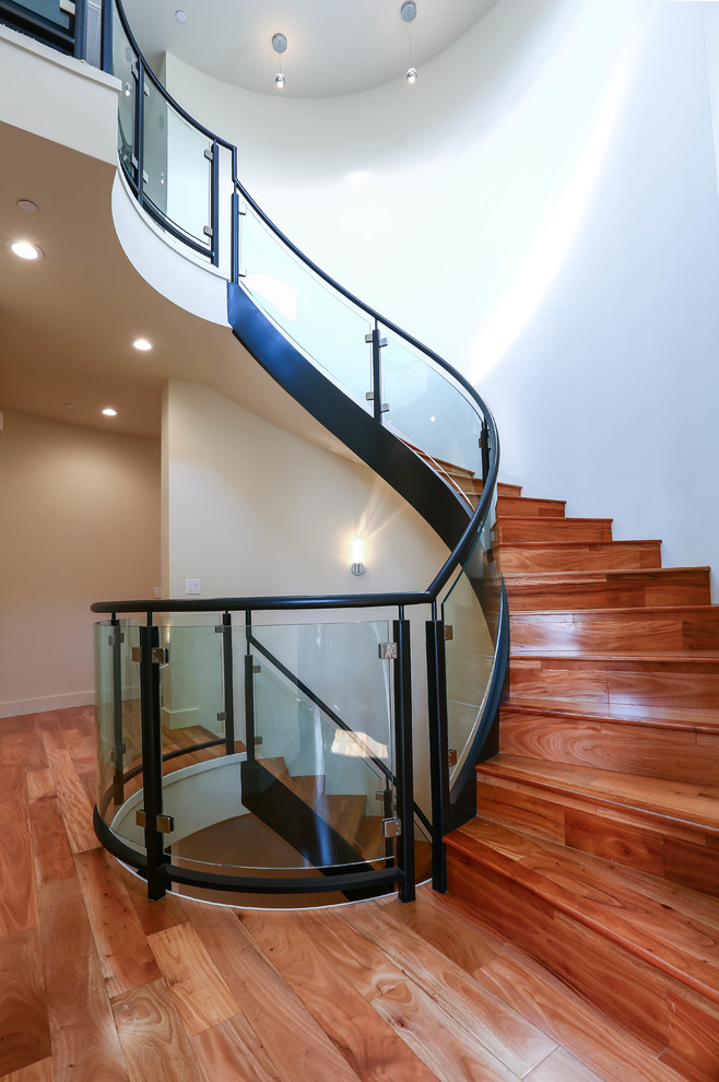 This is an example of an expansive contemporary wood floating staircase in San Francisco with wood risers and glass railing.