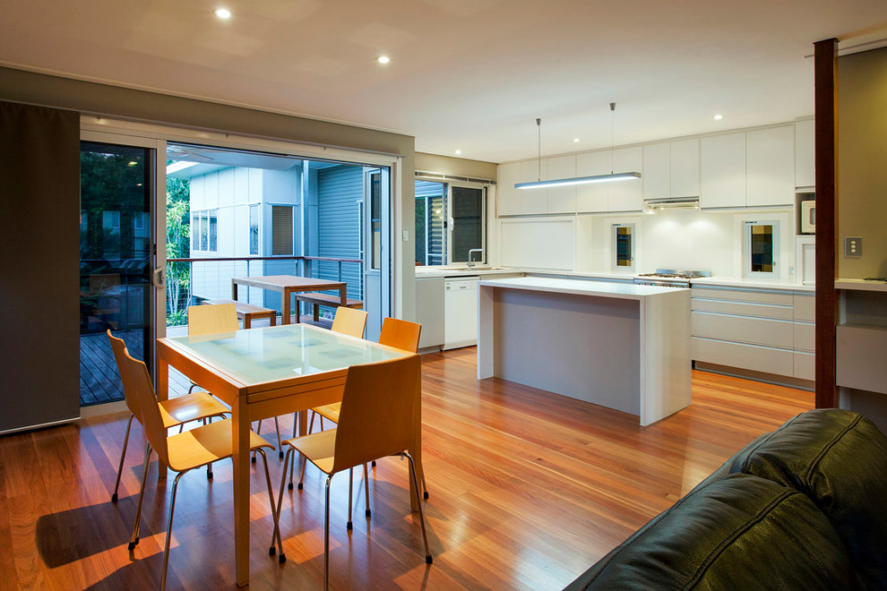 This is an example of a large transitional open plan dining in Brisbane with light hardwood floors, no fireplace and brown floor.