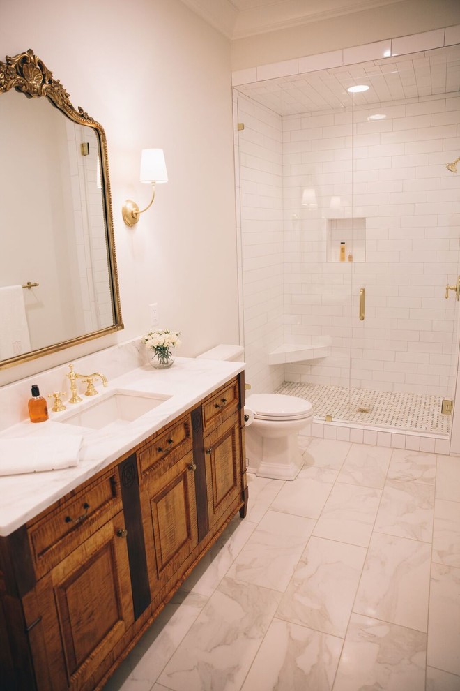 Photo of a mid-sized traditional 3/4 bathroom in Birmingham with an alcove shower, white tile, porcelain tile, porcelain floors, raised-panel cabinets, dark wood cabinets, a one-piece toilet, white walls, an undermount sink and soapstone benchtops.