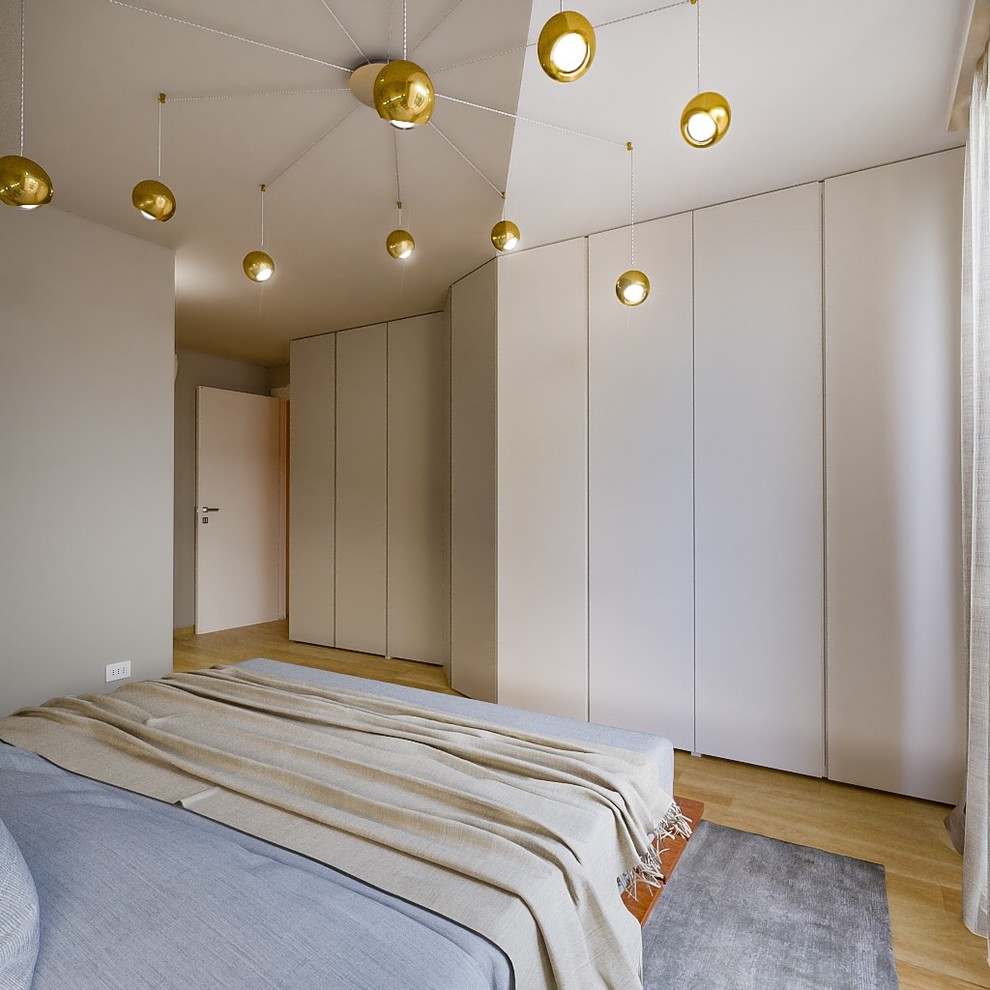 Mid-sized contemporary master bedroom in Milan with beige walls and light hardwood floors.