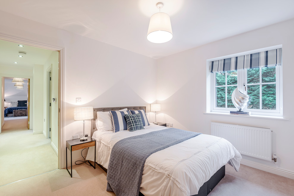 This is an example of a medium sized modern guest bedroom in Berkshire with carpet.
