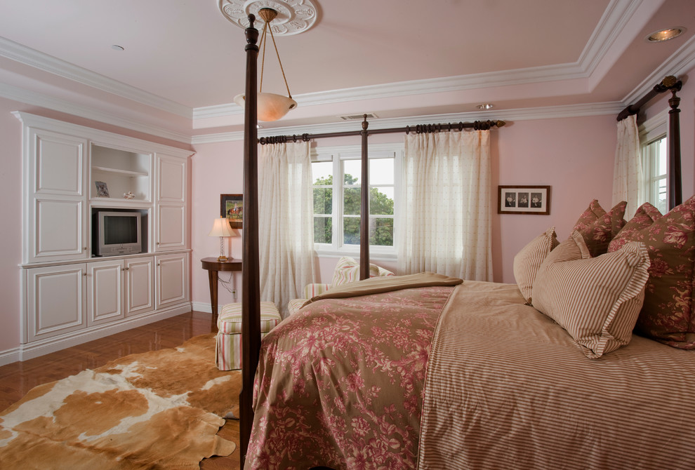 This is an example of a traditional bedroom in Orange County with pink walls.