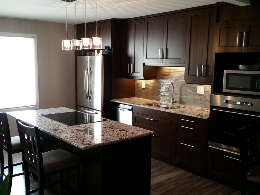 Kitchen - large transitional medium tone wood floor and brown floor kitchen idea with a double-bowl sink, shaker cabinets, dark wood cabinets, granite countertops, gray backsplash, matchstick tile backsplash, stainless steel appliances and an island