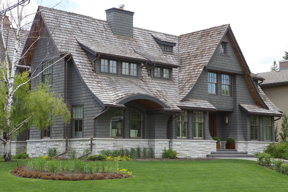 Inspiration for a large traditional three-storey grey exterior in Calgary with wood siding and a gable roof.