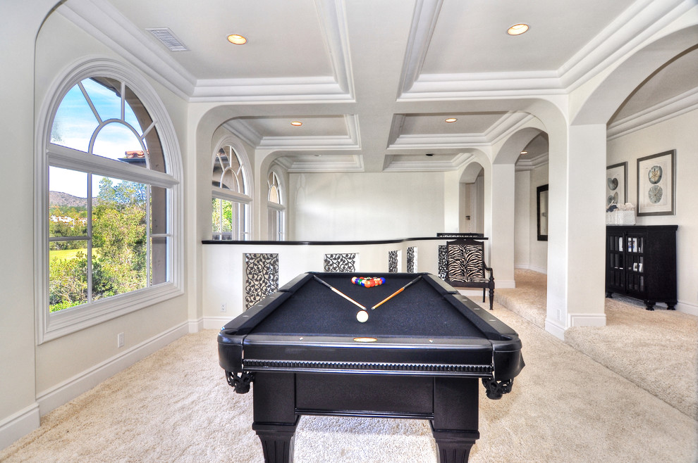 This is an example of a transitional family room in Orange County with a game room, white walls and carpet.
