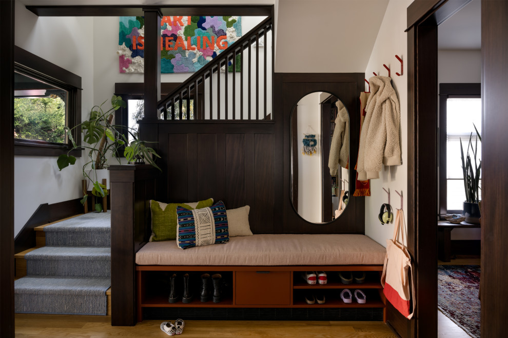 Foyer - mid-sized eclectic medium tone wood floor, brown floor and wood wall foyer idea in Seattle with a dark wood front door and white walls