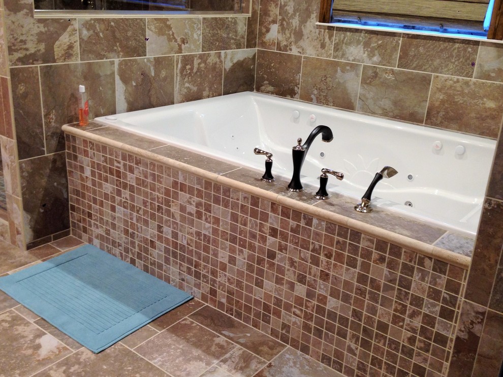 Inspiration for a transitional master multicolored tile and porcelain tile porcelain tile drop-in bathtub remodel with an integrated sink, recessed-panel cabinets, distressed cabinets, solid surface countertops and beige walls