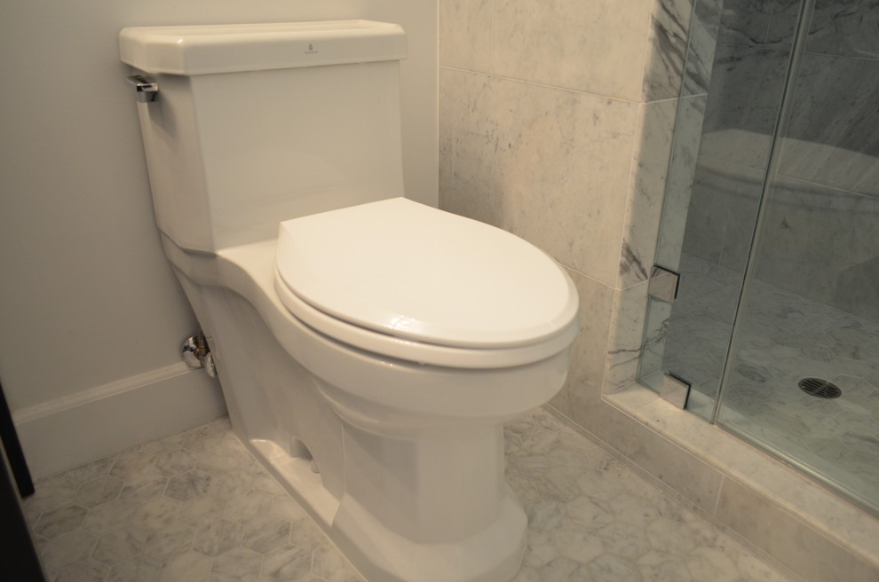 This is an example of a mid-sized traditional 3/4 bathroom in Los Angeles with raised-panel cabinets, white cabinets, a freestanding tub, an alcove shower, a one-piece toilet, gray tile, slate, grey walls, marble floors, an undermount sink, wood benchtops, grey floor, a hinged shower door and white benchtops.