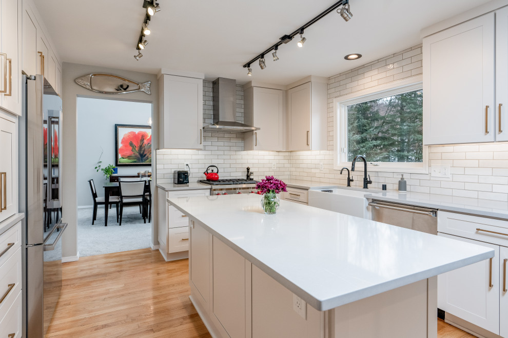 Inspiration for a mid-sized transitional kitchen remodel with shaker cabinets, white cabinets, quartz countertops, white backsplash, an island and gray countertops