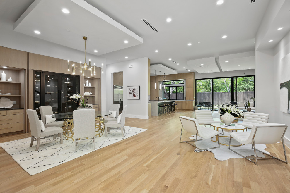Photo of a large modern kitchen/dining combo in Dallas with white walls, light hardwood floors, no fireplace and yellow floor.