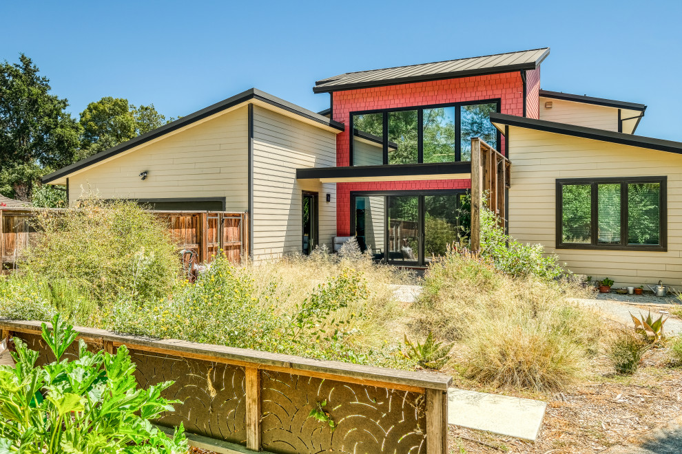 Großes, Zweistöckiges Modernes Einfamilienhaus mit Faserzement-Fassade, bunter Fassadenfarbe, Pultdach, Blechdach, grauem Dach und Verschalung in Sacramento