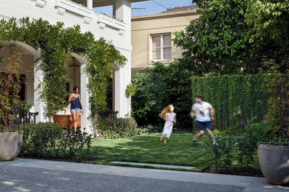 Large contemporary front yard full sun formal garden in Melbourne with a garden path and natural stone pavers for spring.