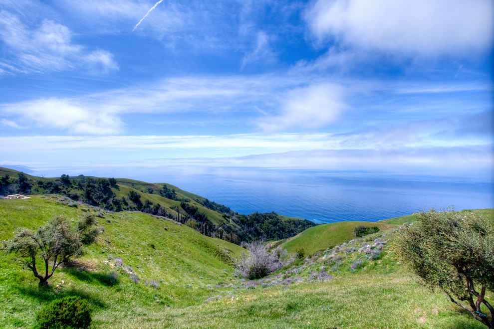 Big Sur Coast Ridge Estate - Breathtaking views of the incomparable Big Sur Coast, this classic Tuscan design of an Italian farmhouse, combined with a modern approach creates an ambiance of relaxed sophistication for this magnificent 95.73-acre, private coastal estate on California’s Coastal Ridge. Five-bedroom, 5.5-bath, 7,030 sq. ft. main house, and 864 sq. ft. caretaker house over 864 sq. ft. of garage and laundry facility. Commanding a ridge above the Pacific Ocean and Post Ranch Inn, this spectacular property has sweeping views of the California coastline and surrounding hills. “It’s as if a contemporary house were overlaid on a Tuscan farm-house ruin,” says decorator Craig Wright who created the interiors. The main residence was designed by renowned architect Mickey Muenning—the architect of Big Sur’s Post Ranch Inn, —who artfully combined the contemporary sensibility and the Tuscan vernacular, featuring vaulted ceilings, stained concrete floors, reclaimed Tuscan wood beams, antique Italian roof tiles and a stone tower. Beautifully designed for indoor/outdoor living; the grounds offer a plethora of comfortable and inviting places to lounge and enjoy the stunning views. No expense was spared in the construction of this exquisite estate.