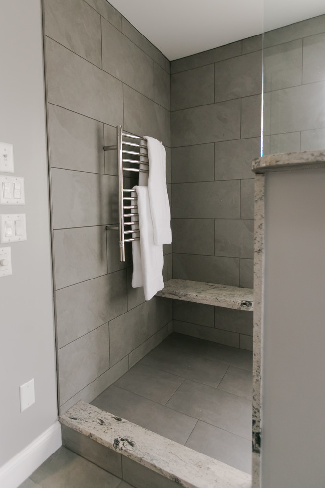 Photo of a mid-sized modern master bathroom in Indianapolis with recessed-panel cabinets, white cabinets, an open shower, a one-piece toilet, gray tile, ceramic tile, grey walls, ceramic floors, a vessel sink, granite benchtops, grey floor, an open shower and grey benchtops.