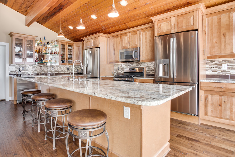Inspiration for a large rustic kitchen remodel in DC Metro with an undermount sink, raised-panel cabinets, granite countertops, glass tile backsplash, stainless steel appliances and an island