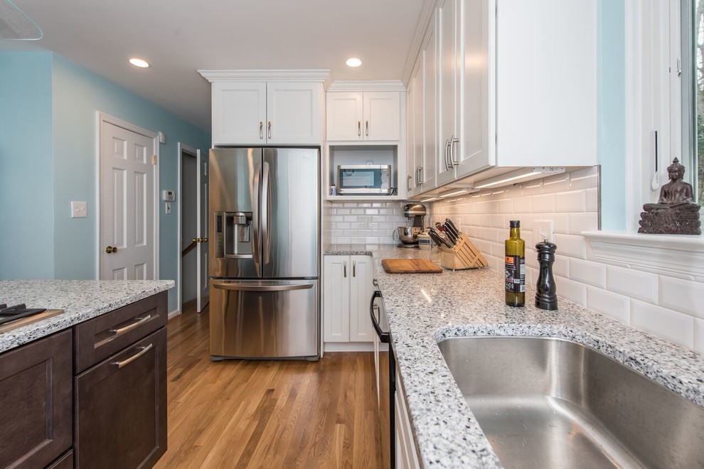 This is an example of a transitional eat-in kitchen in DC Metro with shaker cabinets, white cabinets, quartz benchtops, white splashback, subway tile splashback and stainless steel appliances.