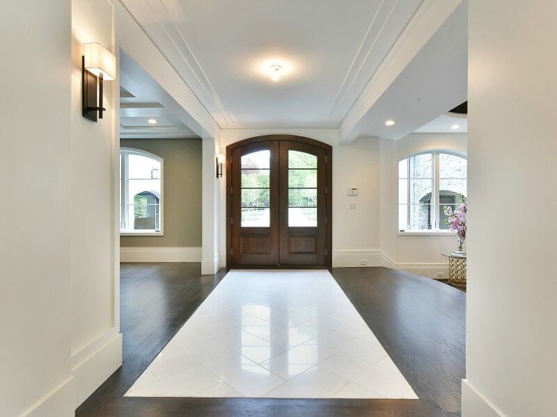 Example of a large transitional dark wood floor front door design in New York with white walls and a dark wood front door