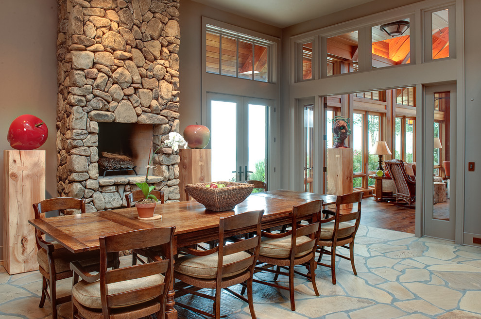 Country dining room in Atlanta with a stone fireplace surround.
