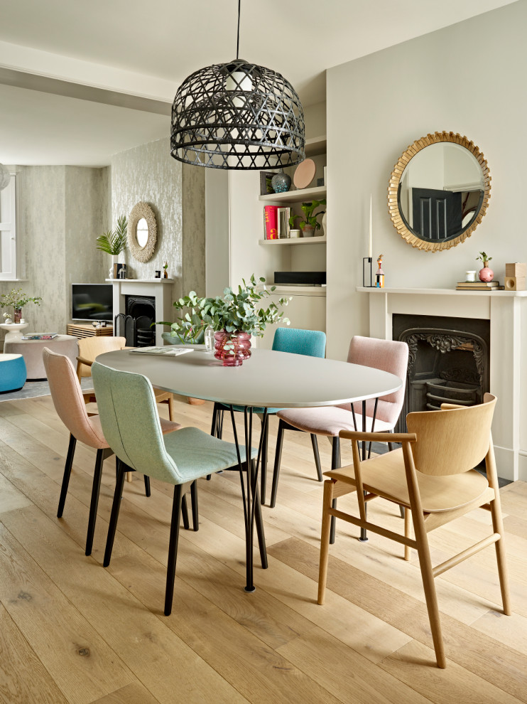 Foto di una sala da pranzo aperta verso il soggiorno contemporanea con pareti grigie, pavimento in legno massello medio, camino classico e pavimento marrone